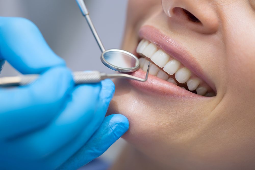 A Woman is Getting Her Teeth Examined by a Dentist — Graham Johnson Dental Surgery In Beresfield, NSW