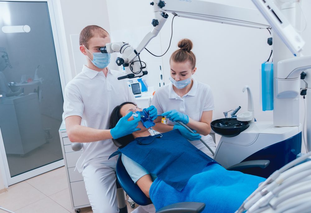A Dentist is Examining a Patient 's Teeth in a Dental Office — Graham Johnson Dental Surgery In Beresfield, NSW