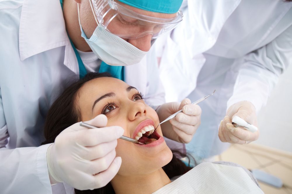 A Woman is Getting Her Teeth Examined by a Dentist — Graham Johnson Dental Surgery In Beresfield, NSW