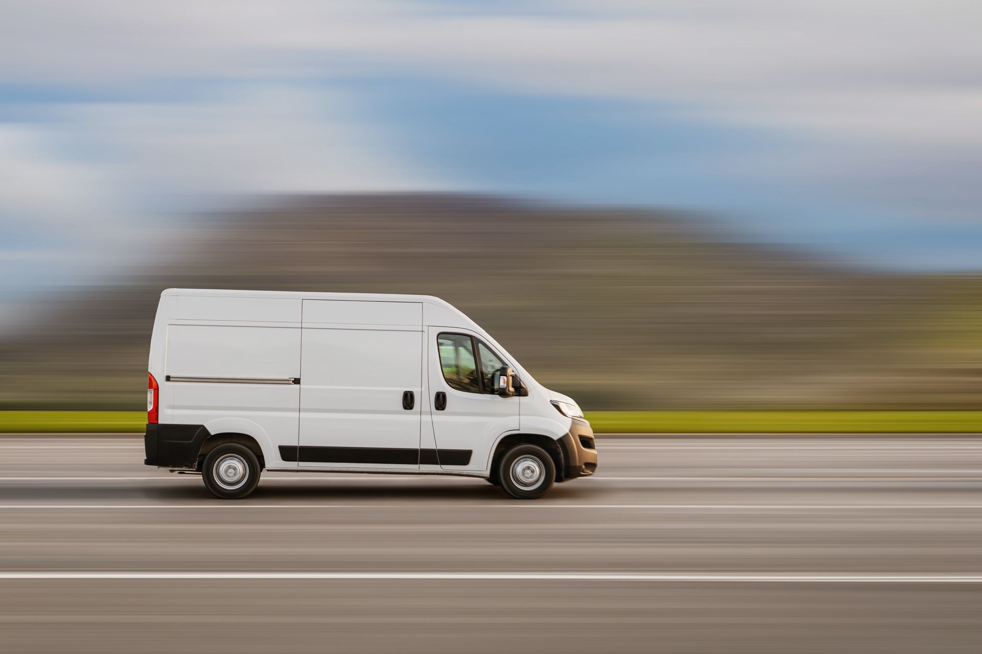 A white van is driving down a highway.