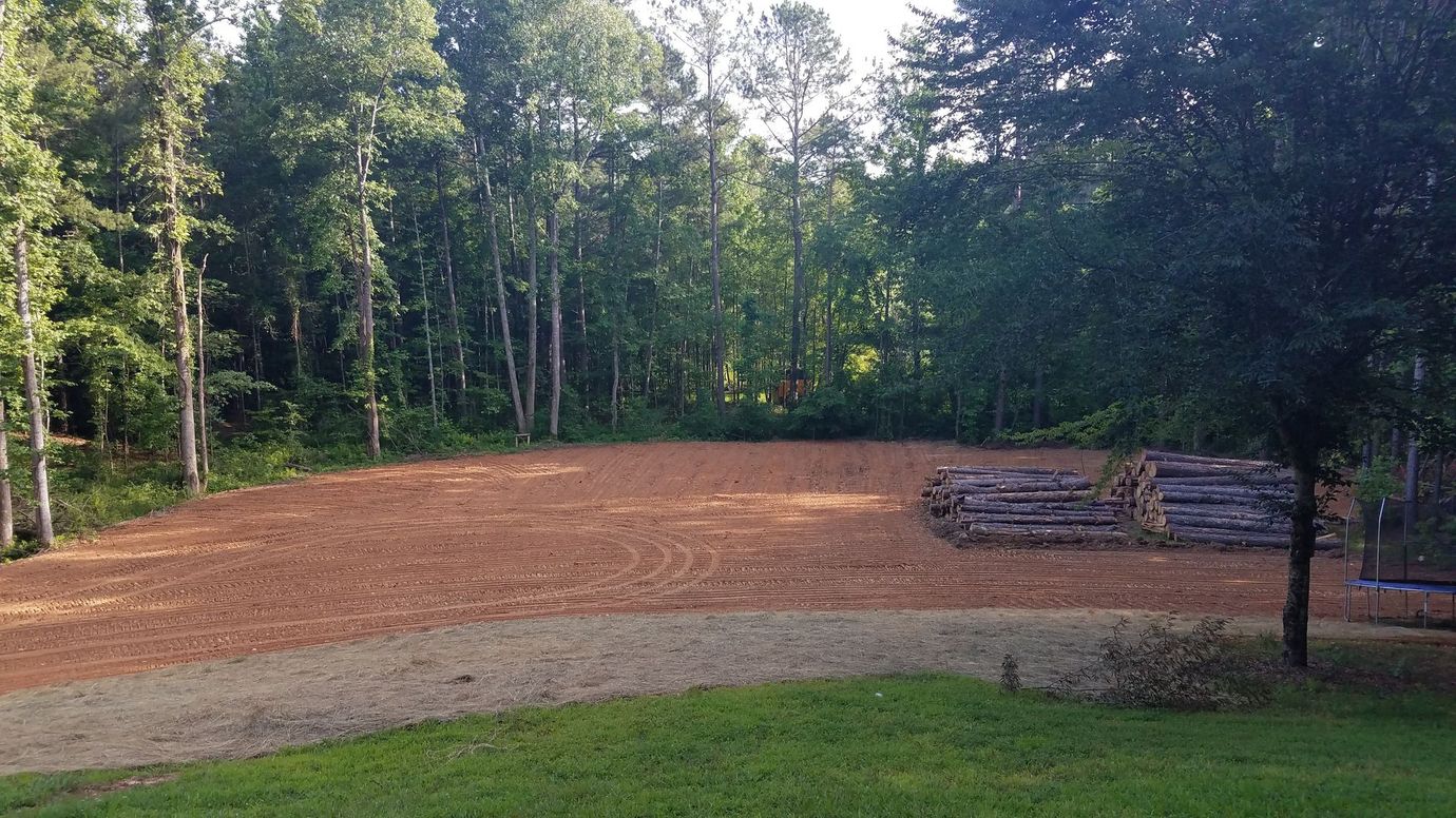 Large RV parked on a graded gravel pad on a wooded North Georgia rural property