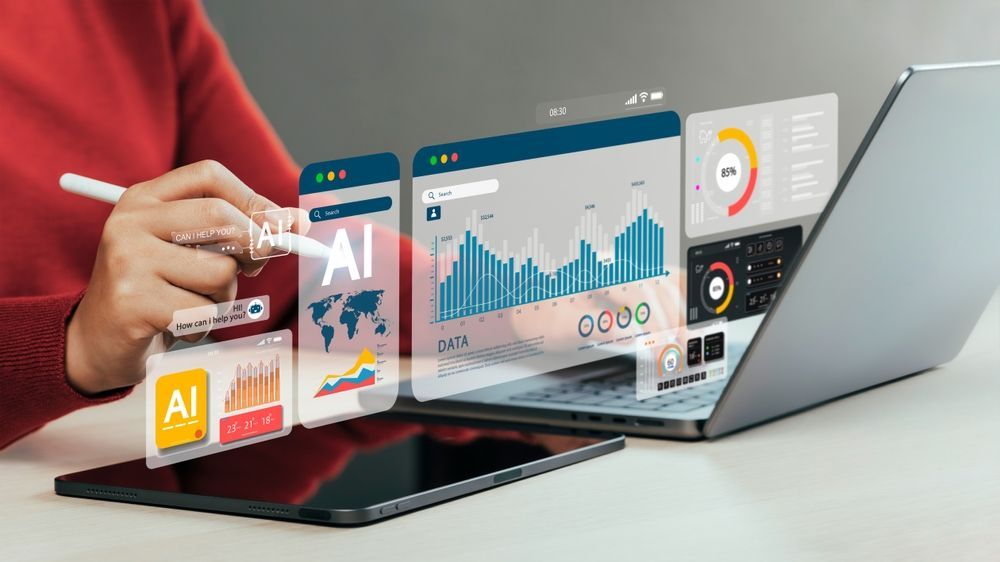Hand using a laptop with floating AI analytics dashboards and charts on a desk