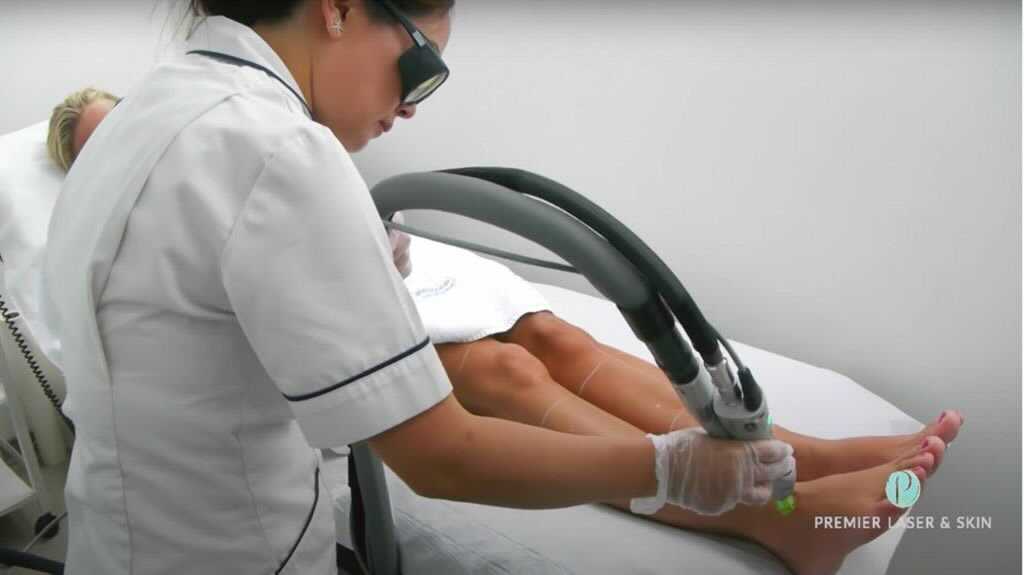 Technician performing laser hair removal on a client's leg.