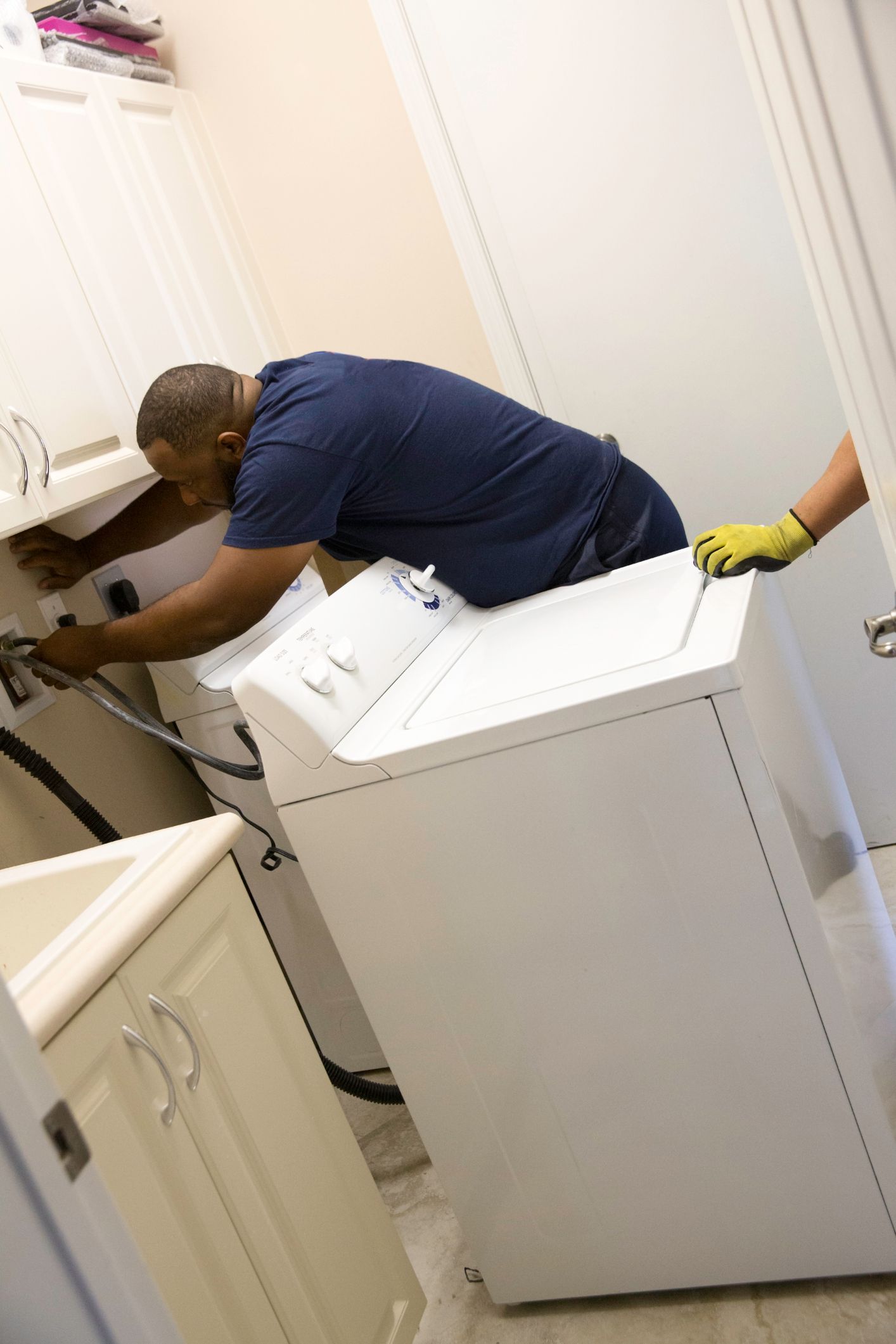Removing Old Washer and Dryer In Laundry Room — Fairport, NY — Terry Rickner Appliance Service Removing Old Washer and Dryer In Laundry Room — Fairport, NY — Terry Rickner Appliance Service