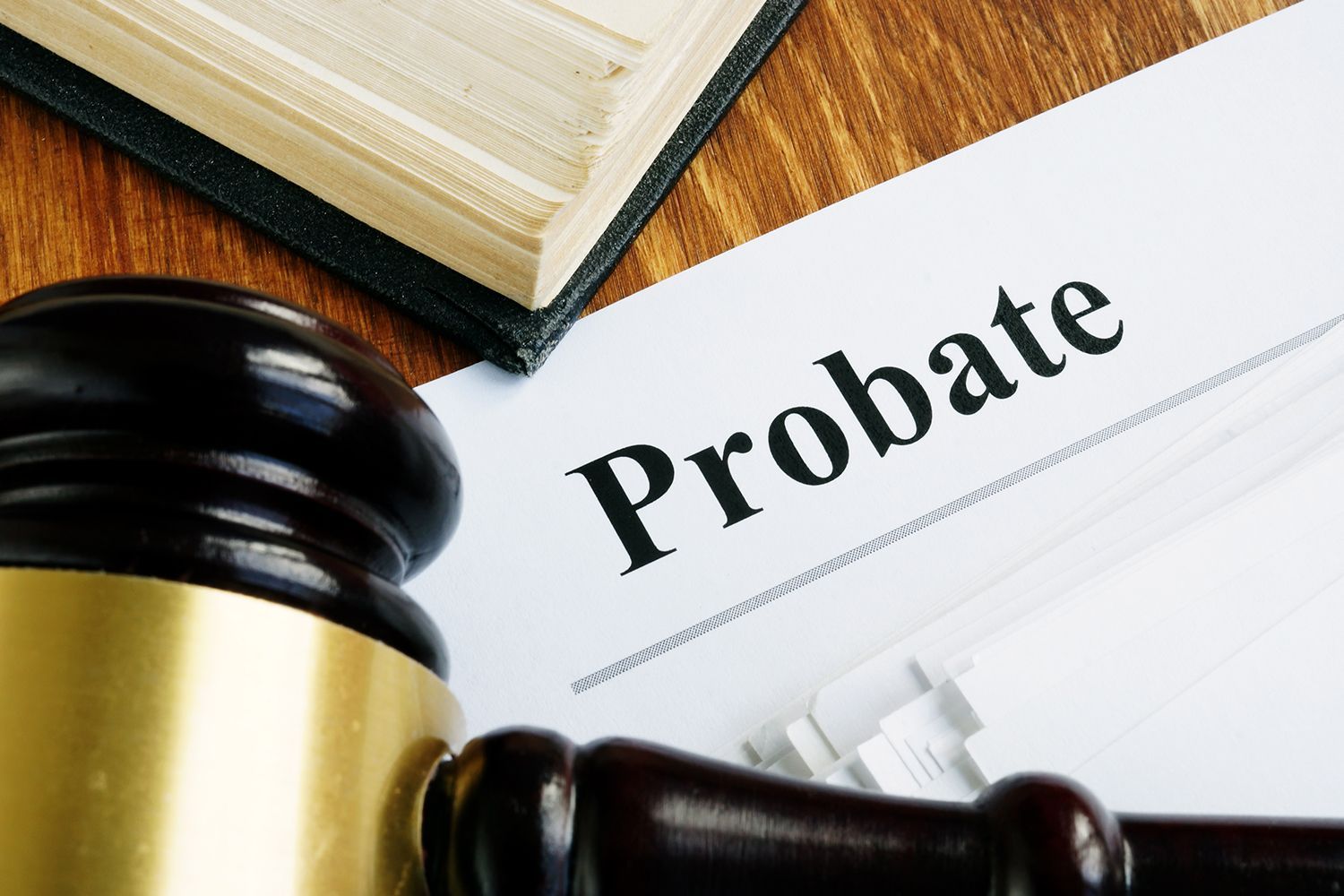 Gavel, open book, and document labeled Probate on a wooden surface.