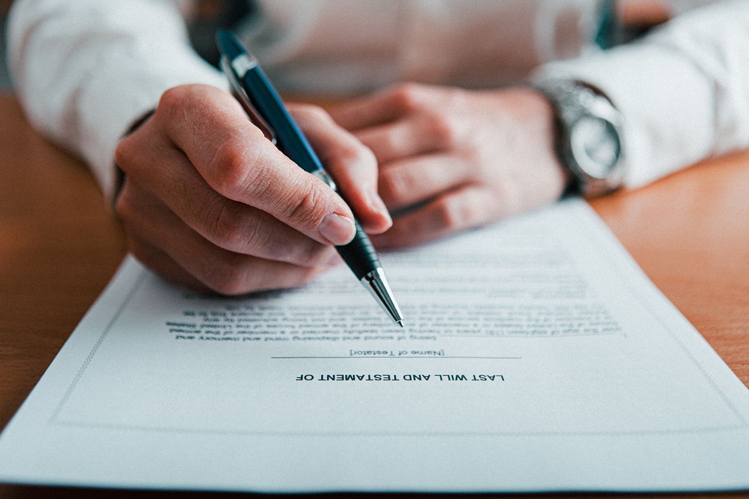 Person signing a document with a pen, close up of hands and watch. Person signing a document with a pen, close up of hands and watch.