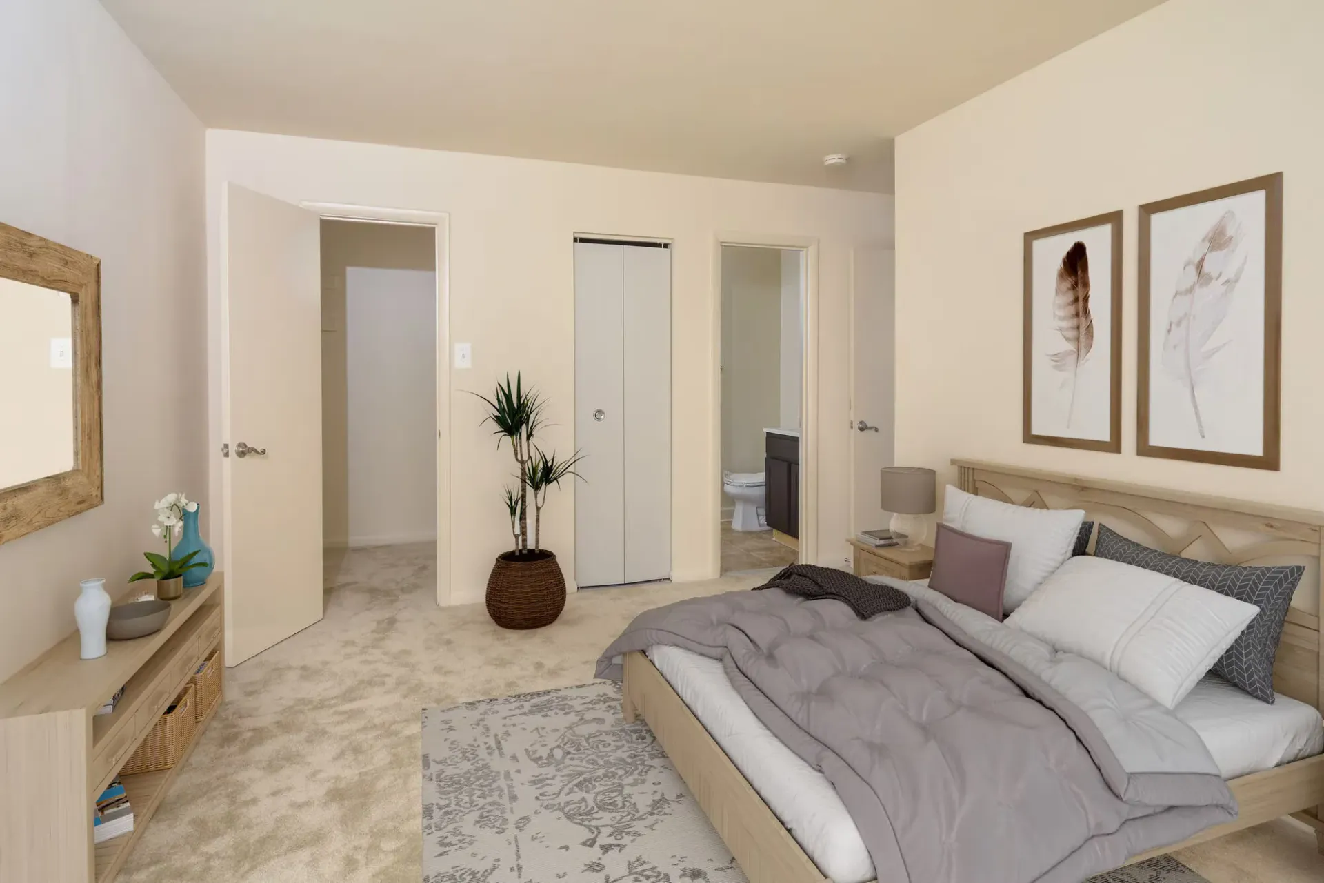 Bedroom in an apartment with a wooden bed frame, two nightstands, plant, and closet doors.