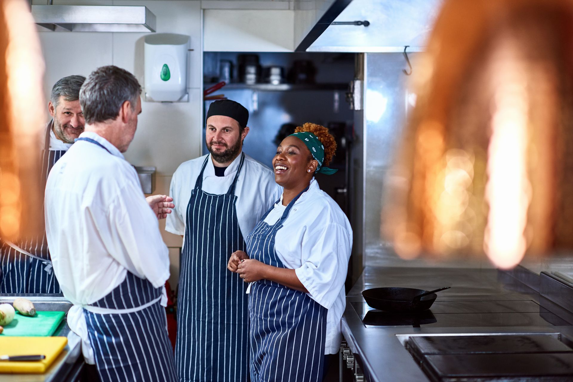 A Group of Chefs are Standing in a Kitchen Talking to Each Other — Naples, FL — Enduring Business Solutions, LLC