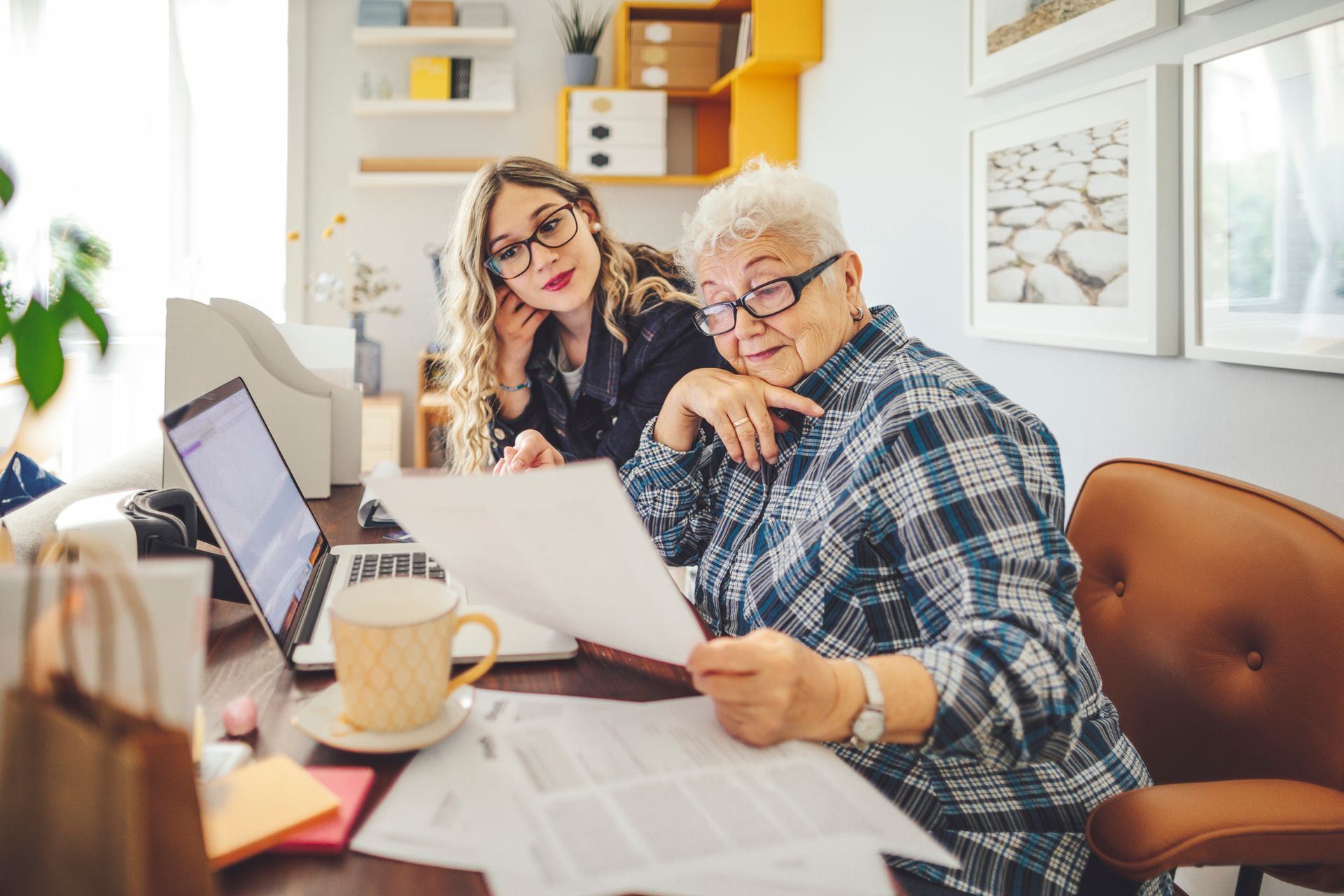 Two Women are Sitting at a Desk Looking at a Piece of Paper — Naples, FL — Enduring Business Solutions, LLC