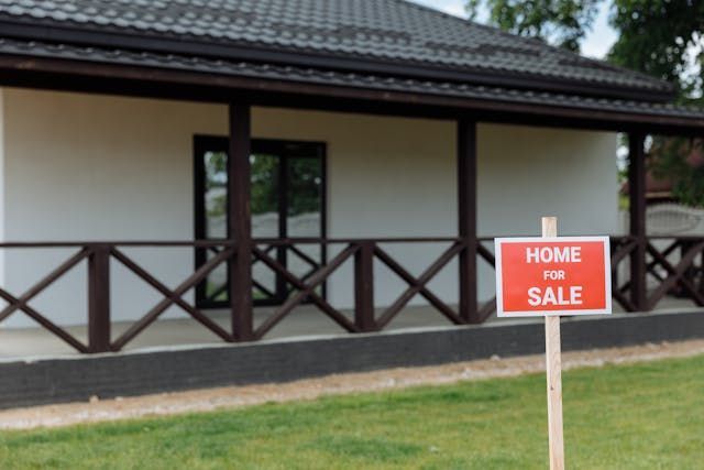 Red home for sale sign in front of a house
