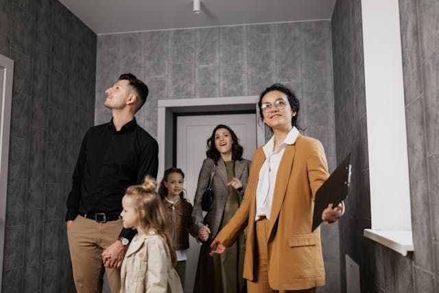 Five people looking around while standing in the entrance of a house