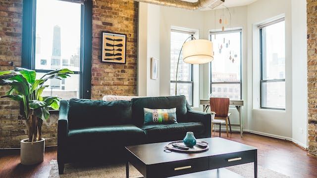 a living room with brick walls and a green couch