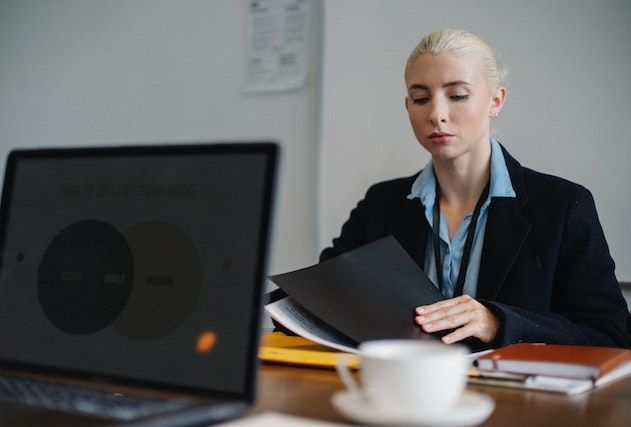 a property manager in a suit sitting at a desk looking over contracts
