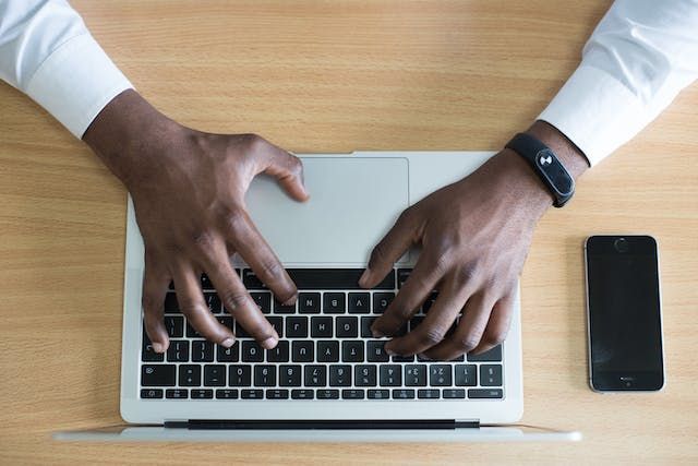 hands typing on a laptop keyboard