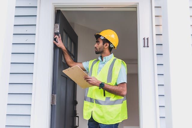 property inspector looking at a doors hinges