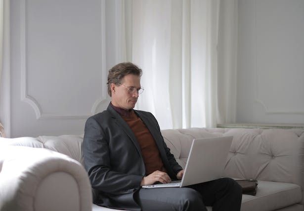 property manager sitting on a couch working on a computer