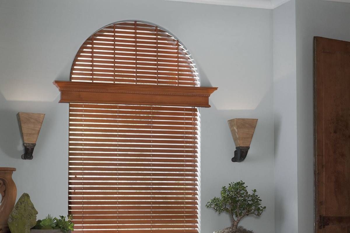 Wooden blinds decorating an arched window in a modern home at Alton Bay Blinds near Hampton, NH