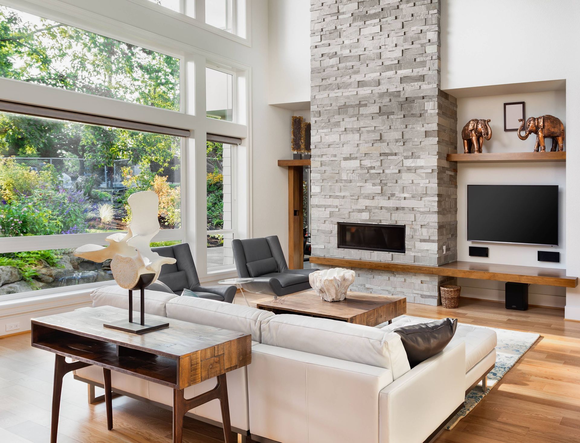 Stylish living room with tall, wide windows, in need of window treatments, in a residential home at