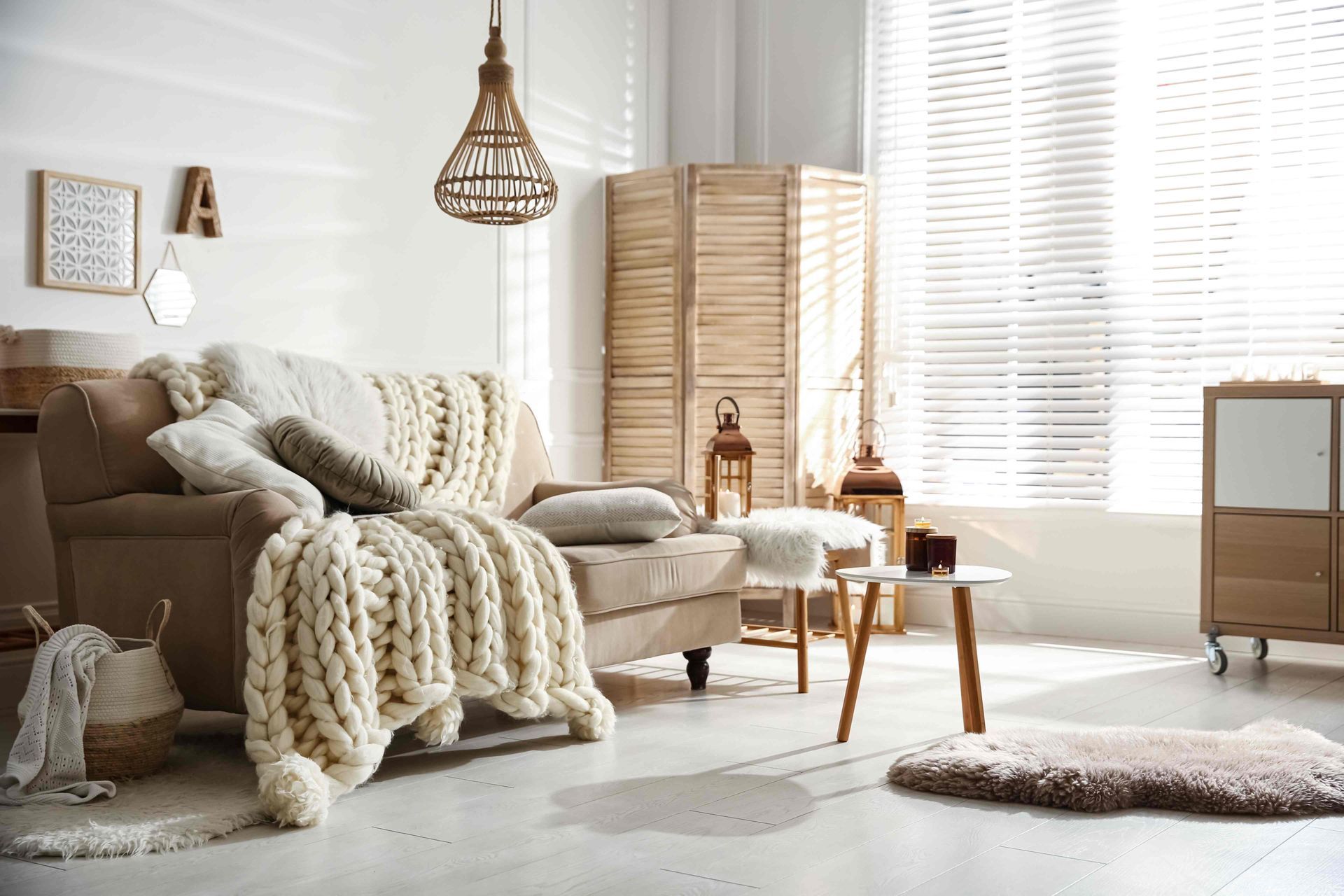 Living room window with shutters in a space featuring a couch and a chunky knit blanket at Alton Bay