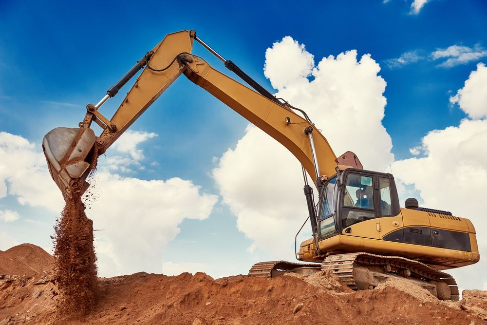 Yellow Excavator Dumping Dirt — DJ Brazil Pty Ltd in Bowen, QLD