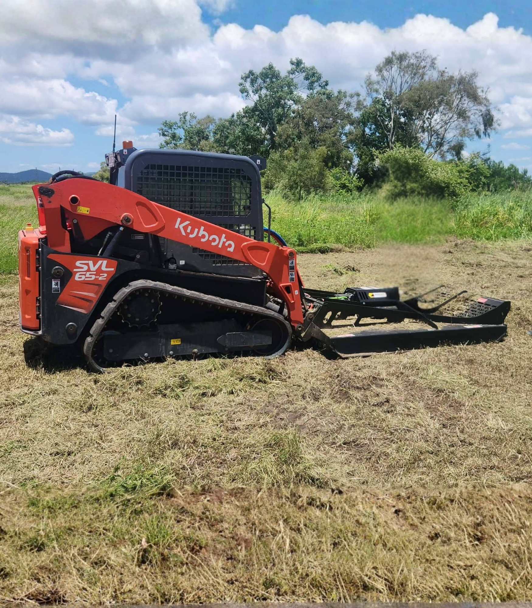 Red Tractor Plowing a Field — DJ Brazil Pty Ltd in Ayr, QLD