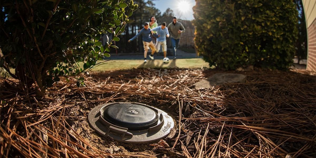 A group of people are walking in a yard next to a manhole cover — Border Pest Control In Albury, NSW