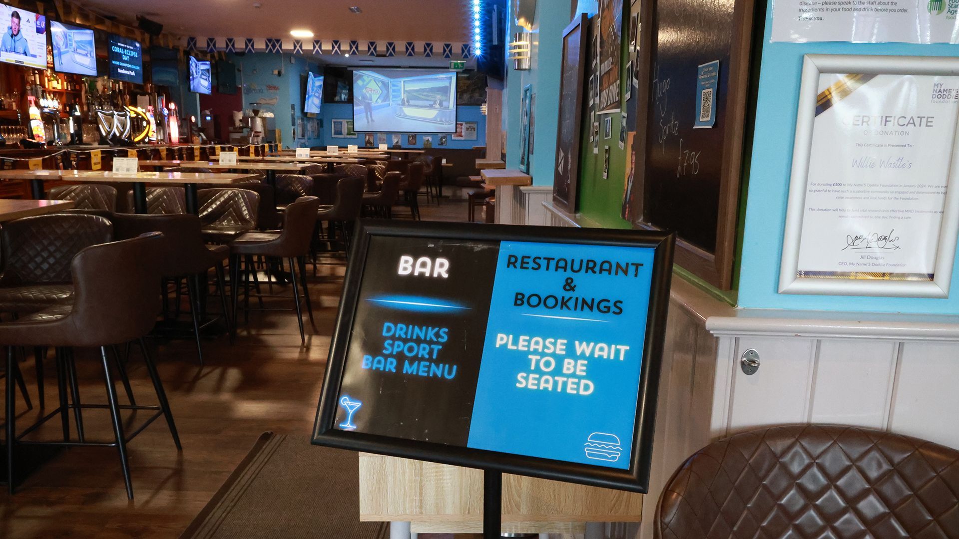 Restaurant entrance with blue signboards reading “Reserved for bookings” and “Please wait to be seated.”