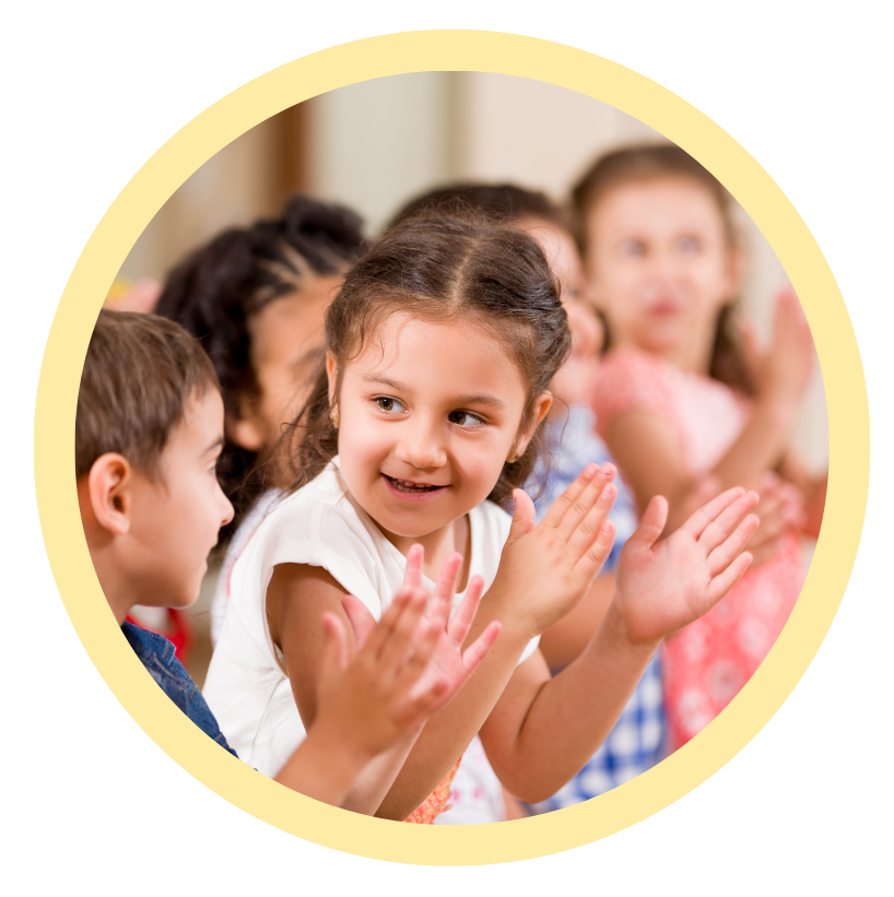 A group of children are clapping their hands together in a circle.