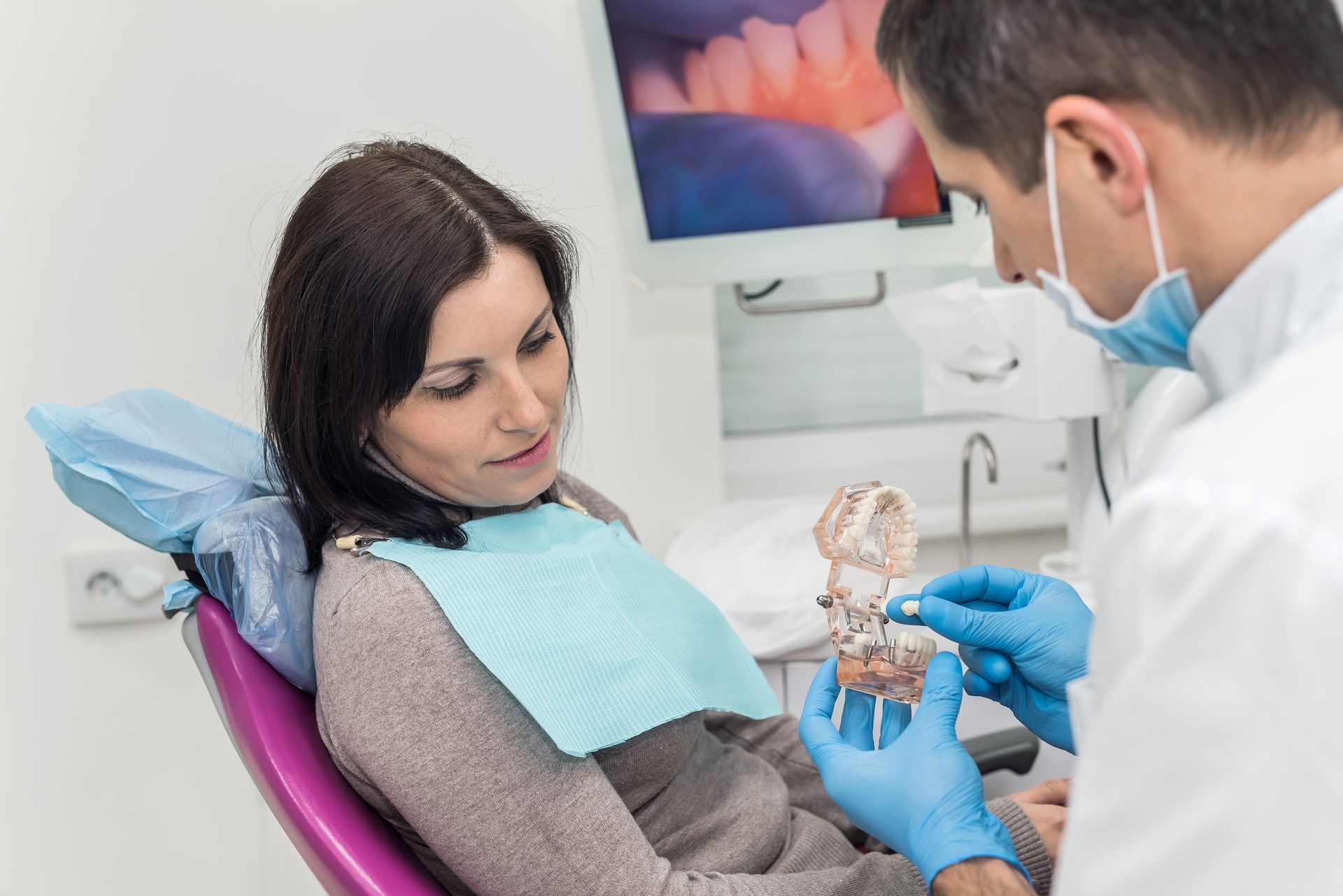 A dentist is explaining a dental restoration procedure to a patient.