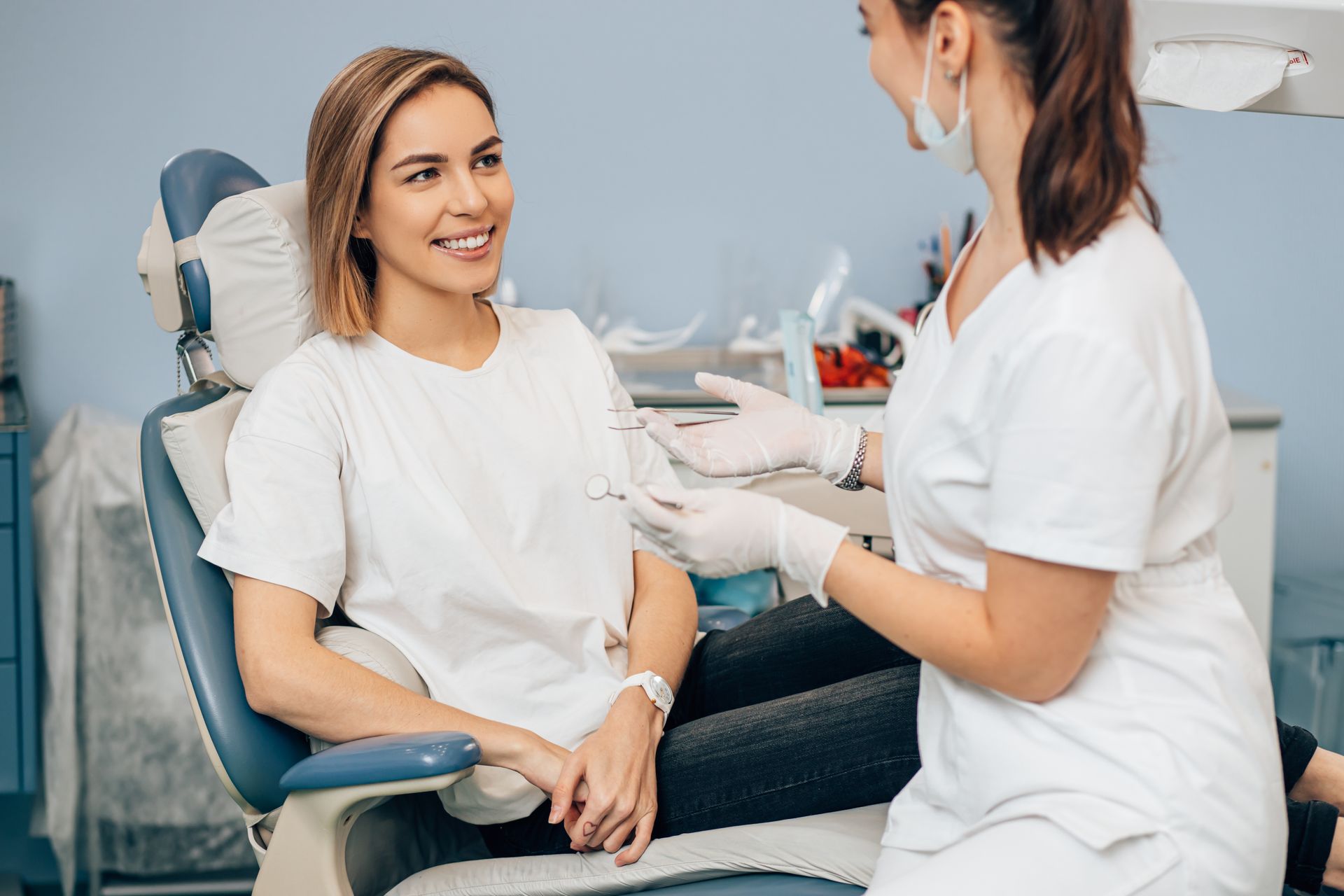 A patient sitting in a dental care having a conversation with her dentist.