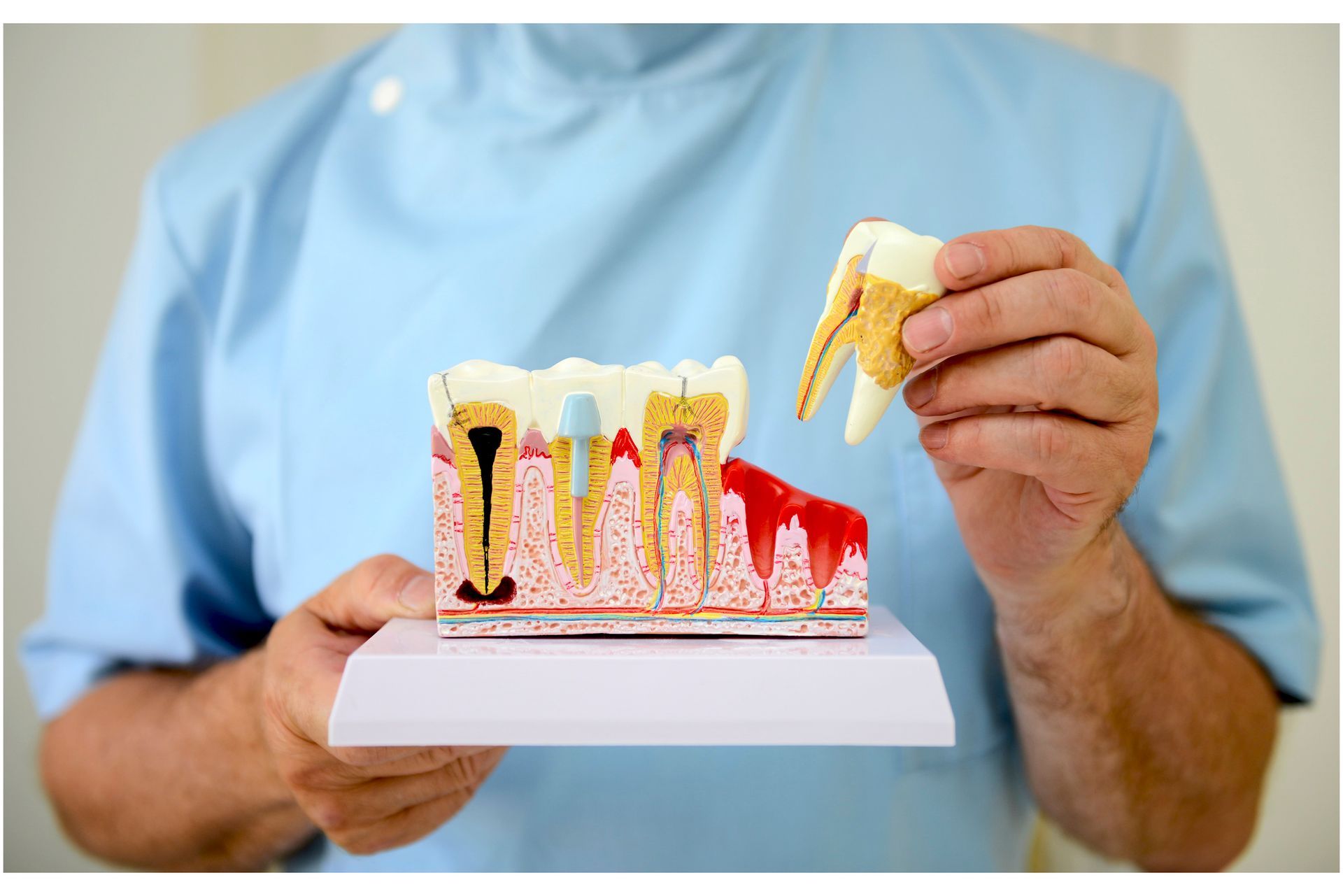 A dental mirror is being used to look at a person 's teeth.