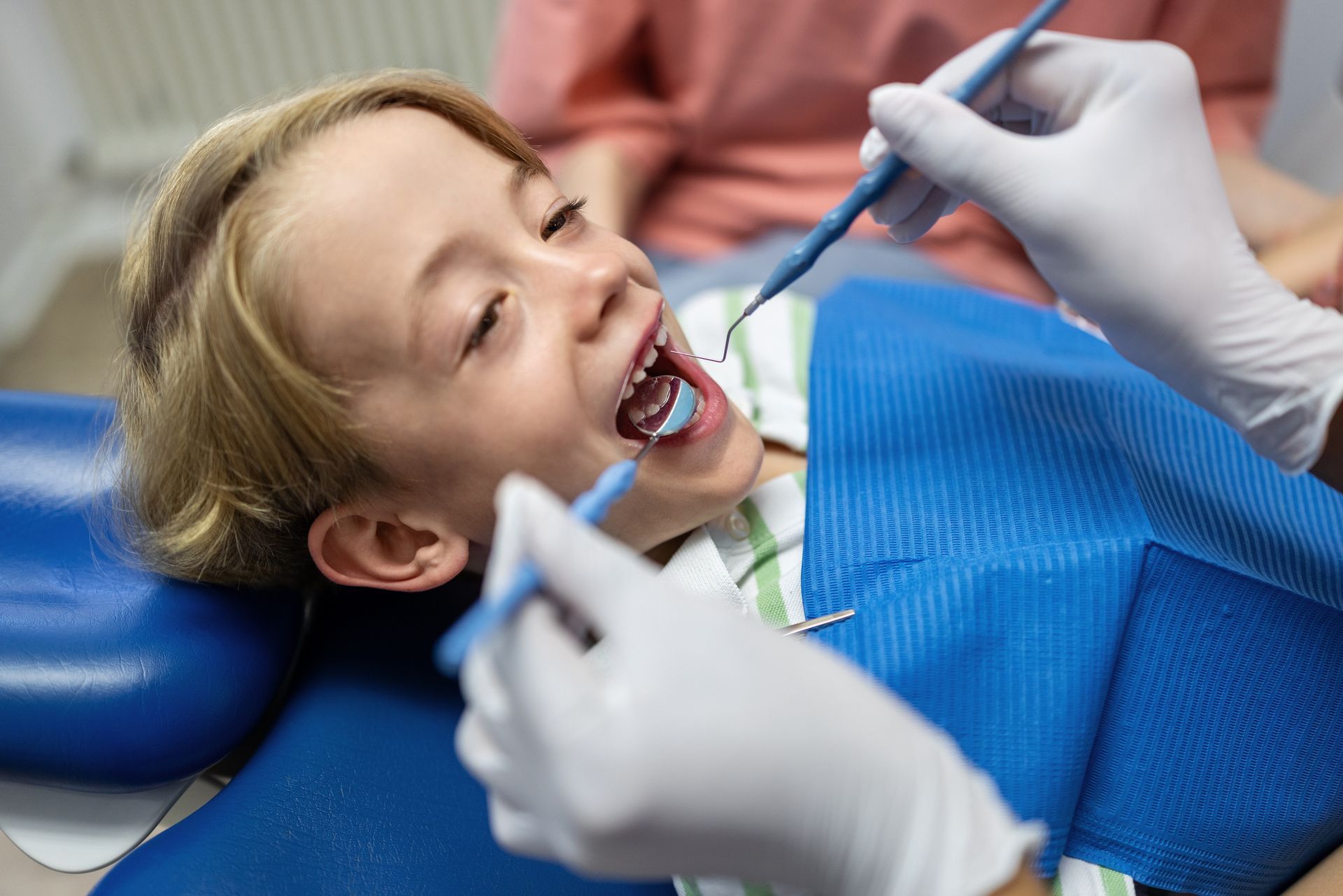 A young boy is undergoing a dental procedure at a paediatric dental clinic.
