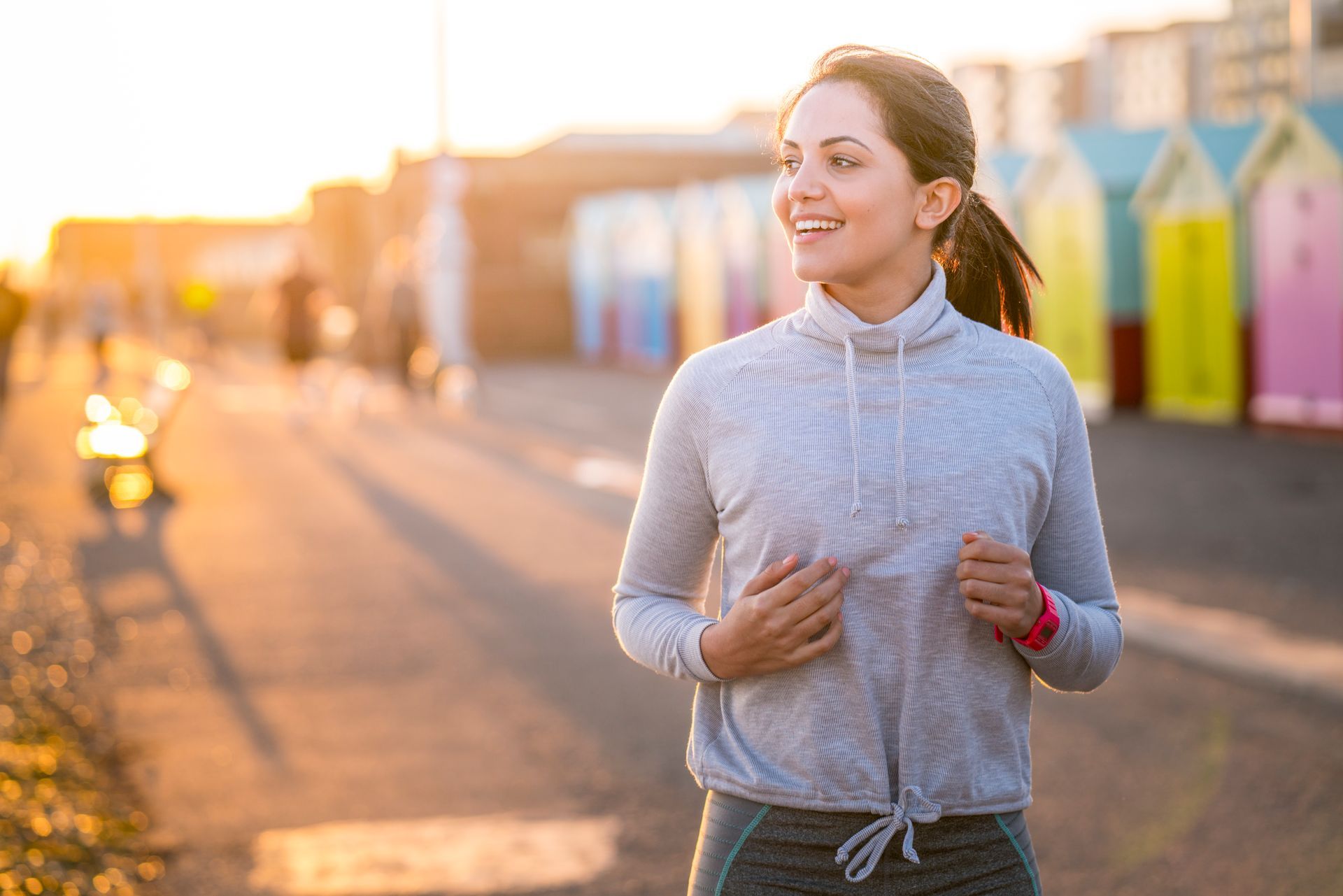 A woman is running on a beach at sunset.