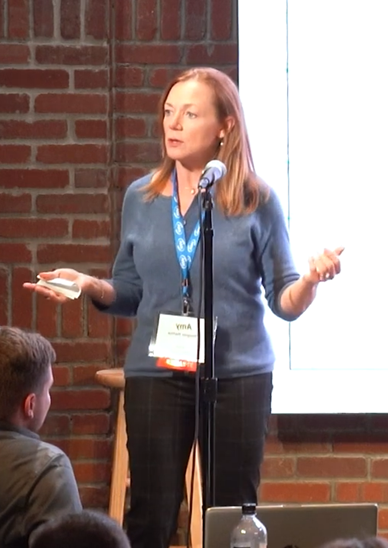 Amy Hooper Hanna delivering a keynote address at a podium