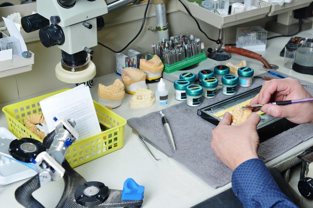 A Person is Working on a Dental Model — Dental Prosthetics By Richard & Cindy in Labrador, QLD