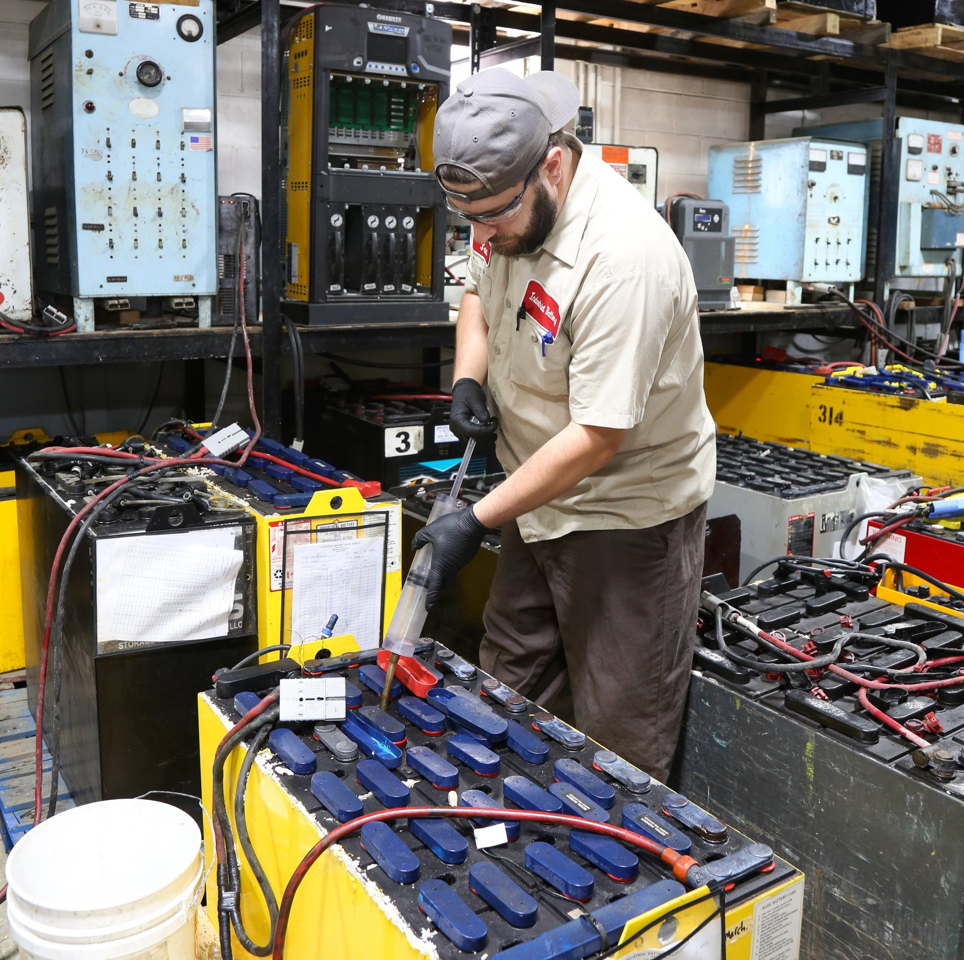 A man is working on a battery with the number 3 on it