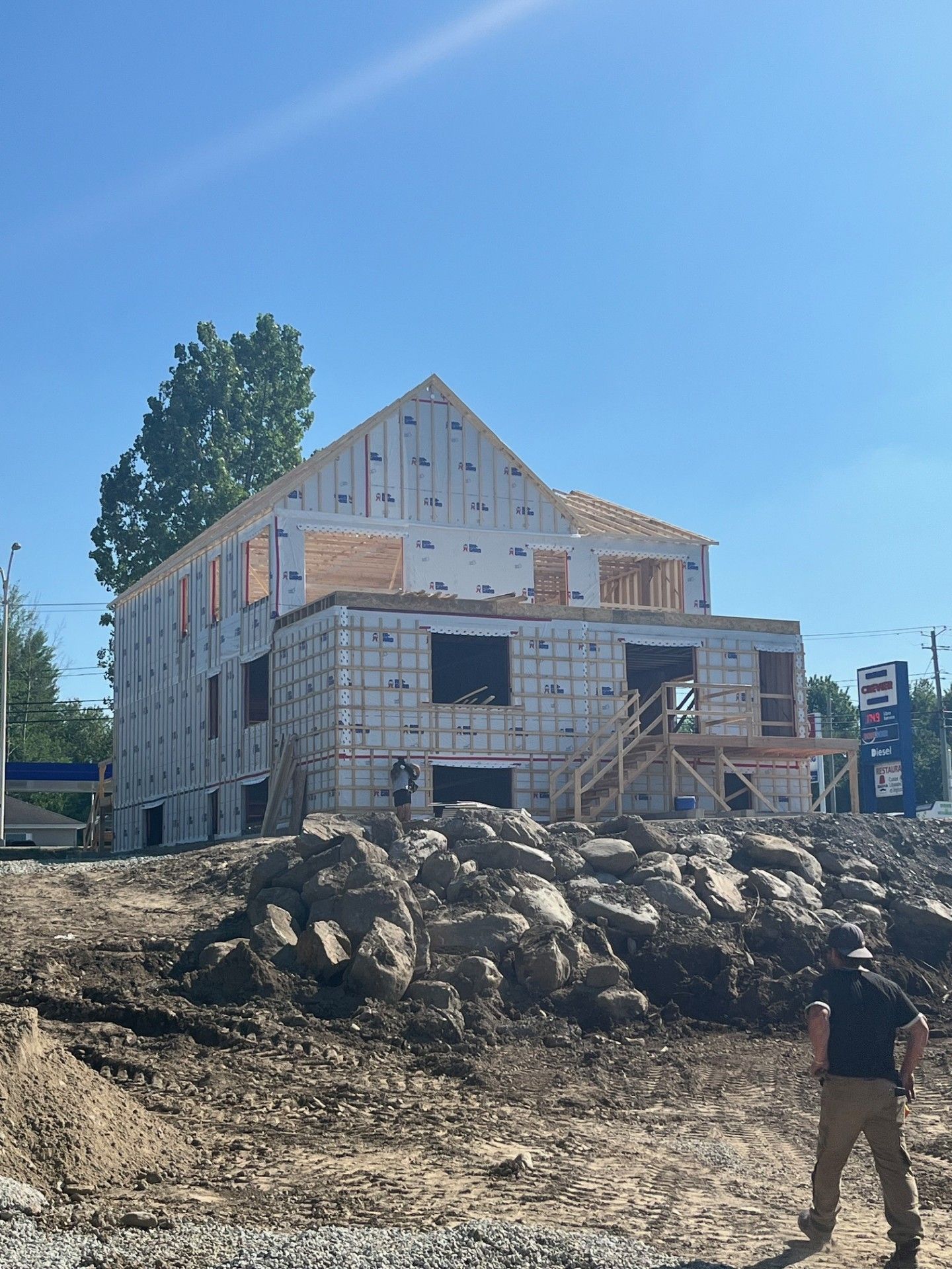 Un homme se tient devant un bâtiment en construction.