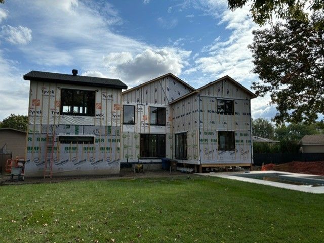Une grande maison avec beaucoup de fenêtres est en construction.