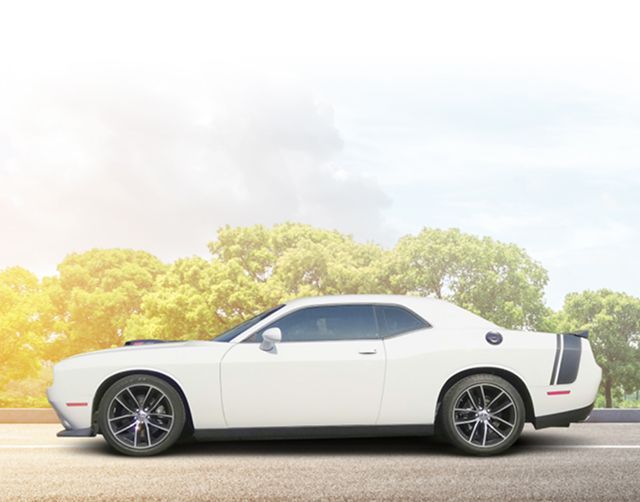 White sports coupe parked on a road with trees in the background and bright sunlight from the left | PC Auto Repair