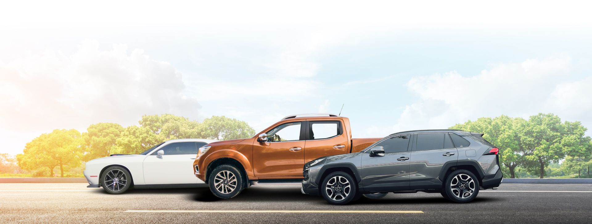 Three cars parked side by side on a road: white sedan, orange pickup, and dark gray SUV near trees. | PC Auto Repair