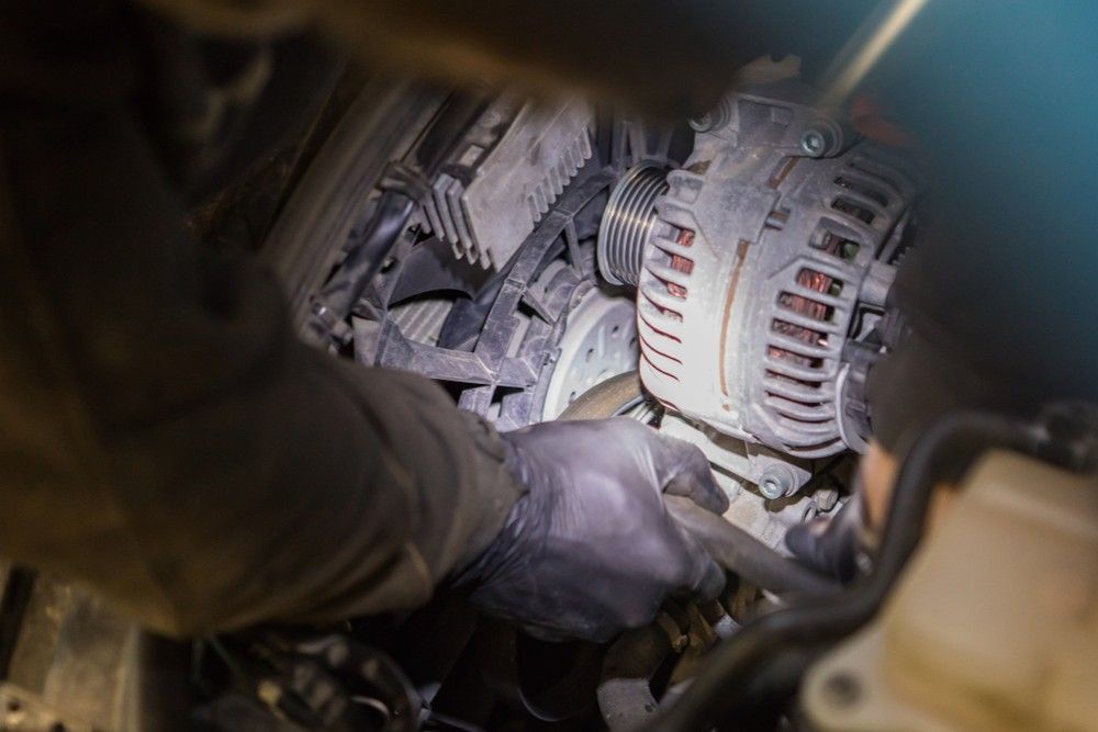 A Person is Working on a Car Engine With a Flashlight — Reliable Bus and Truck Repairs In Caloundra West, QLD