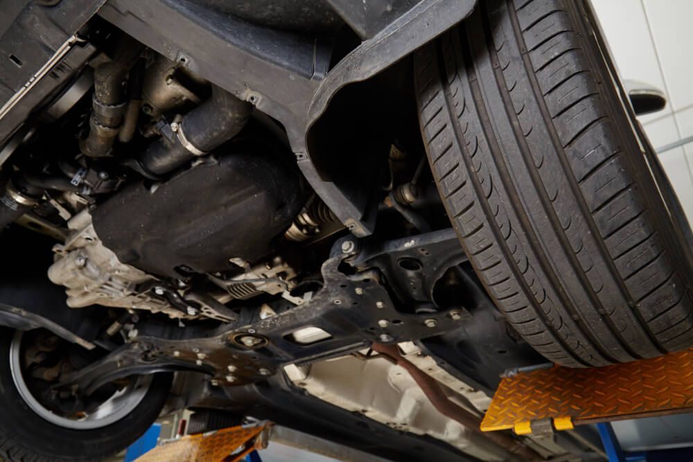 A Close Up of the Underside of a Car on a Lift — Reliable Bus and Truck Repairs In Caloundra West, QLD