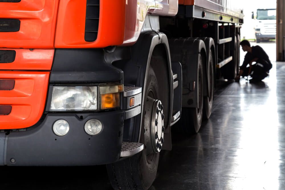 A Man is Working on a Truck in a Garage — Reliable Bus and Truck Repairs In Caloundra West, QLD