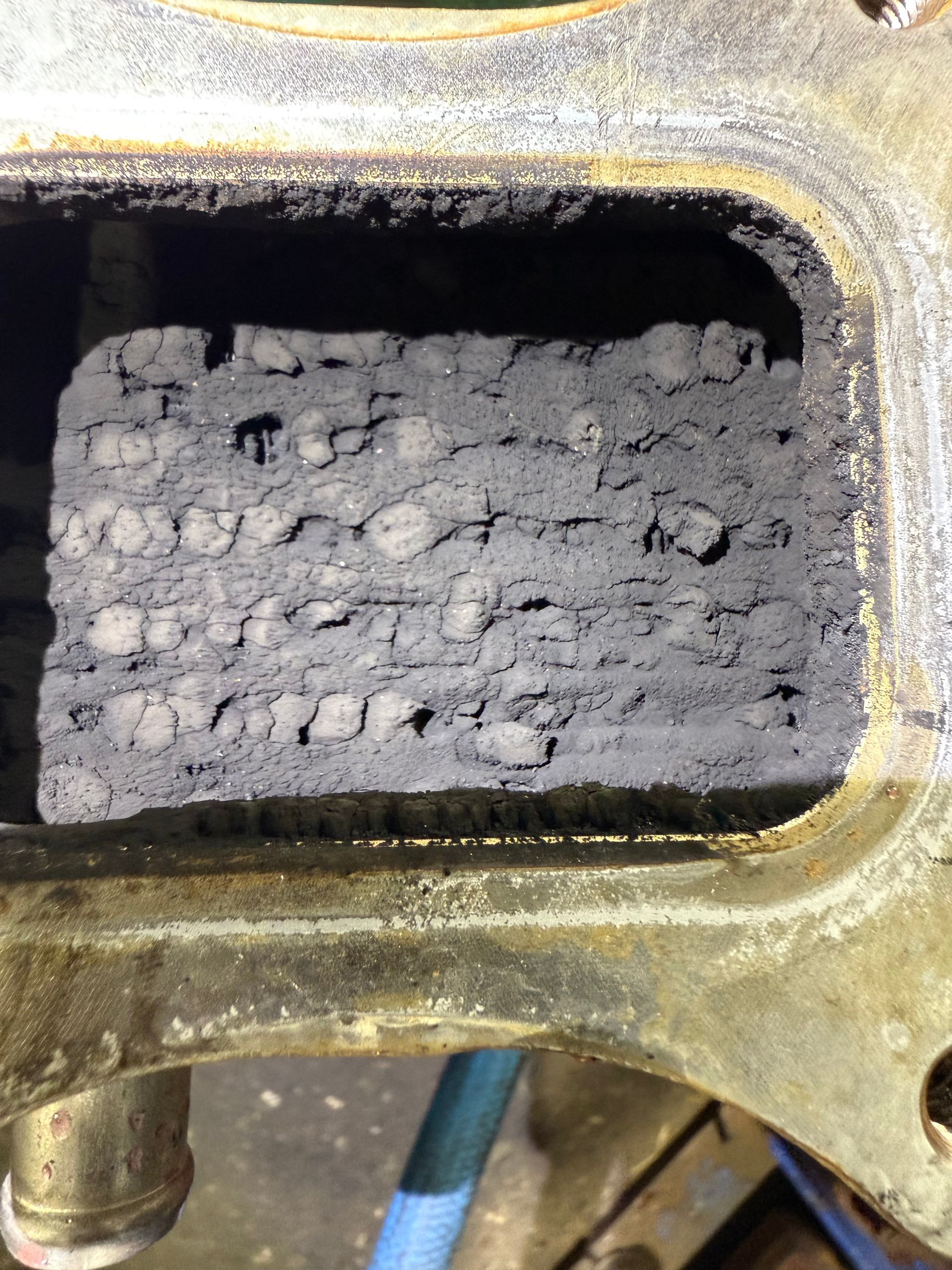 Close-up of a Corroded Metal Port Filled With Gray Buildup and Debris — Reliable Bus and Truck Repairs In Caloundra West, QLD