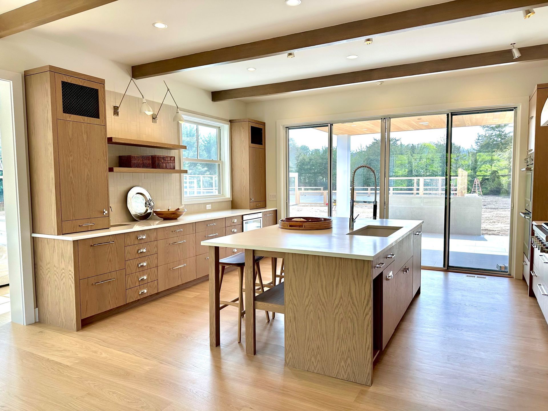 Modern kitchen with wooden cabinets, island, and large sliding glass doors to a patio
