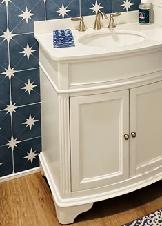 Spa bathroom with a white jetted tub, wood vanity, beige tiled walls, and dark door