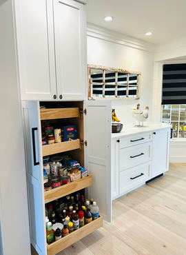 Empty modern walk-in closet with dark shelves, wooden counters, and a central mirrored cabinet