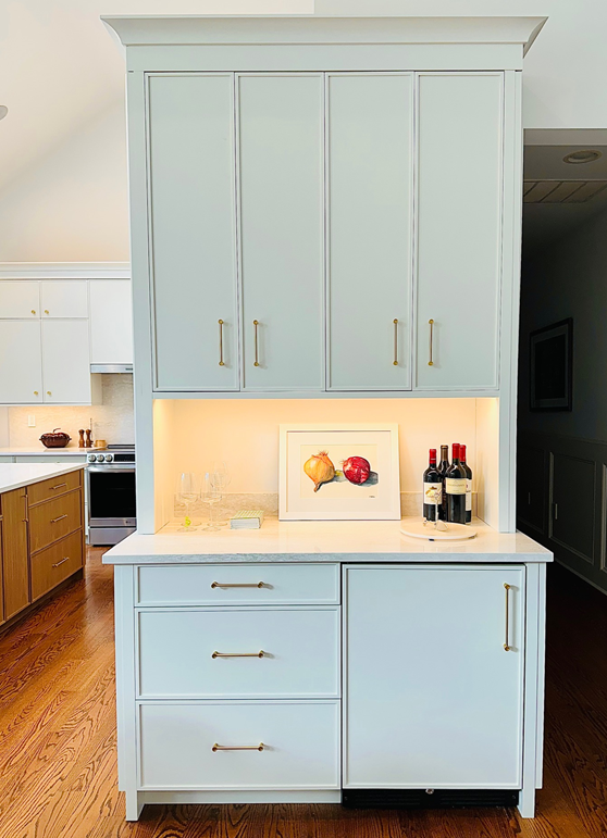 Built-in kitchen storage with light blue cabinets, white countertop, and under-cabinet lighting
