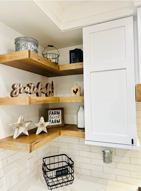 Modern laundry room with wood shelving, hanging plants, woven baskets, and a washer-dryer set.