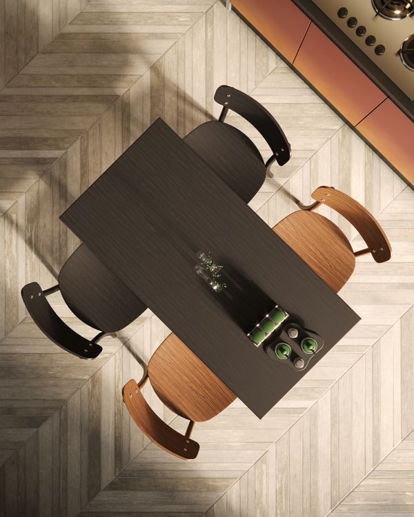 Top-down view of a modern dining table with four chairs on a patterned floor.